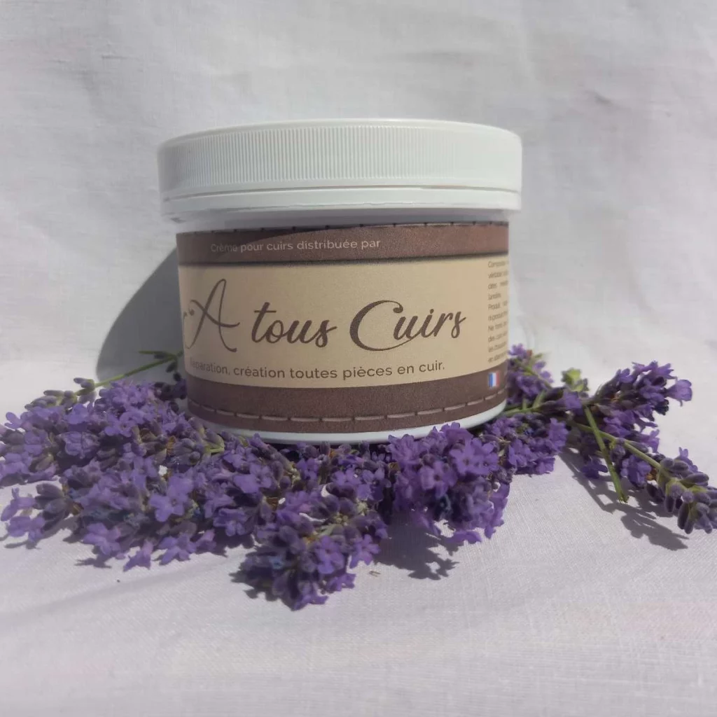 Pot de crème A Tous Cuirs en Gironde avec brins de lavande sur tissu blanc, ambiance artisanale et authentique,